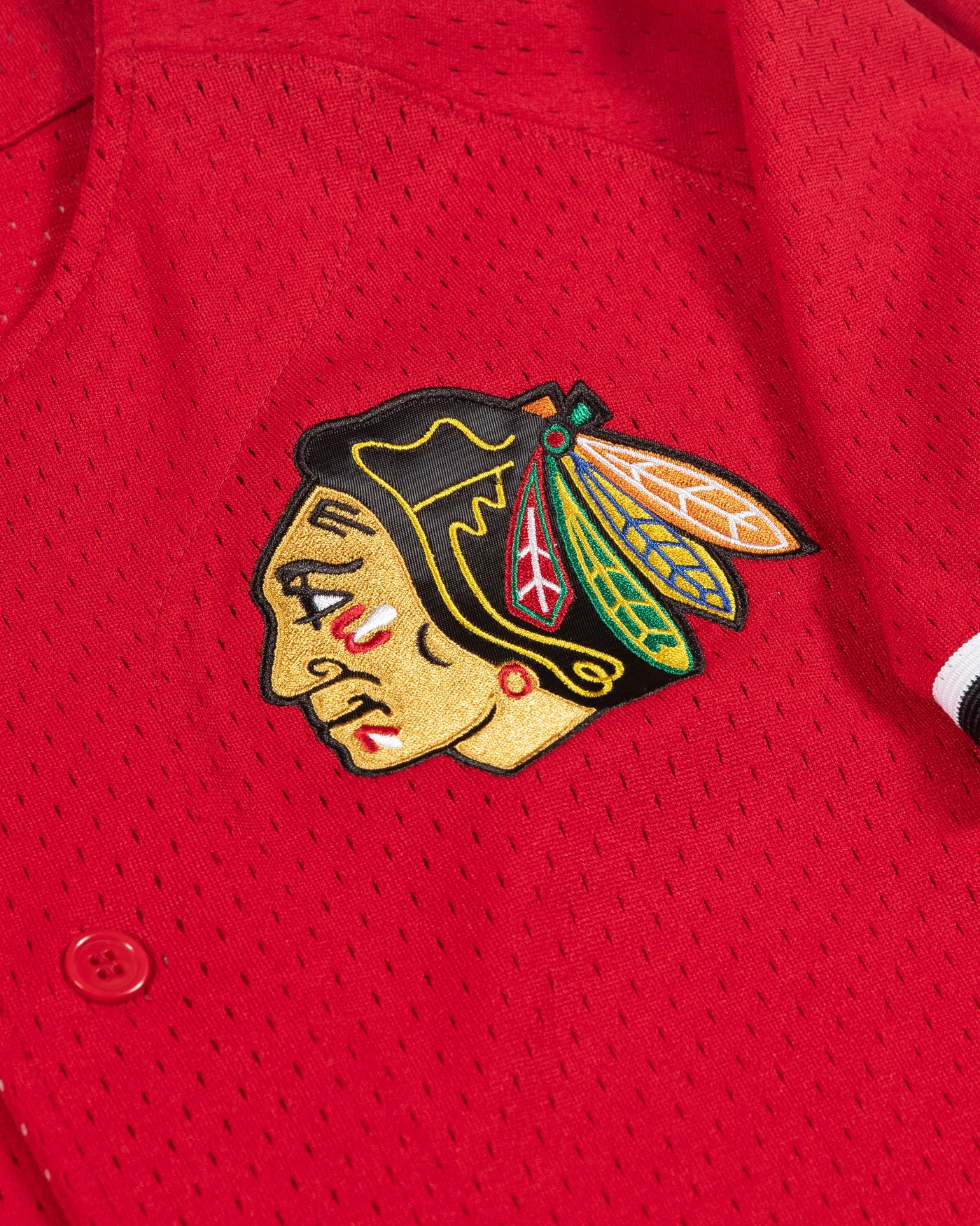 red Mitchell & Ness baseball inspired jersey with Chicago Blackhawks primary logo on left chest and secondary logo on right shoulder - detail logo lay flat