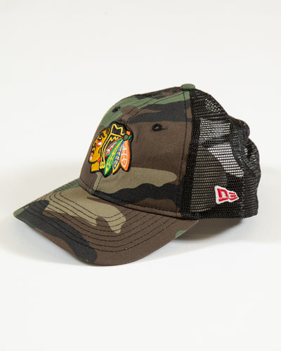 camo New Era youth trucker snapback with Chicago Blackhawks primary logo embroidered on front - left angle lay flat