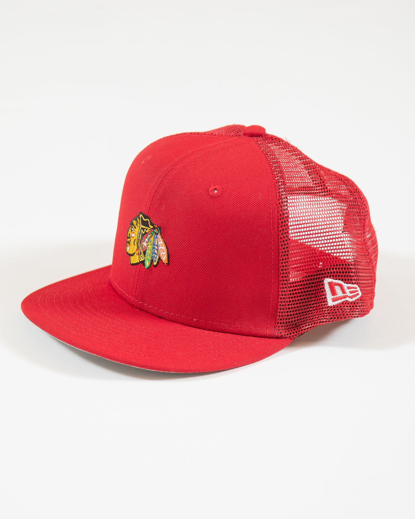 red youth New Era trucker cap with Chicago Blackhawks primary logo embroidered on front - left angle lay flat