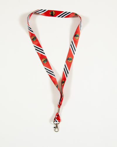 Chicago Blackhawks branded red lanyard with primary logo on repeat with jersey inspired design - front lay flat