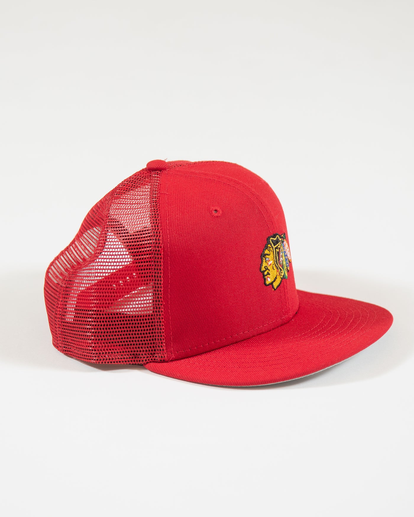 red youth New Era trucker cap with Chicago Blackhawks primary logo embroidered on front - right angle lay flat
