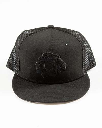Black New Era adjustable trucker cap with tonal Chicago Blackhawks primary logo embroidered on the front - front lay flat