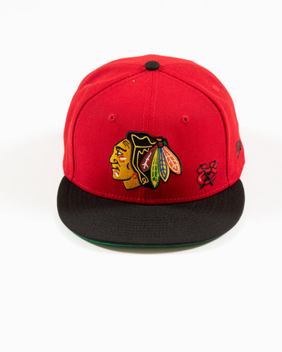 Red and black New Era snapback with Chicago Blackhawks primary logo and secondary logo embroidered on front - front lay flat