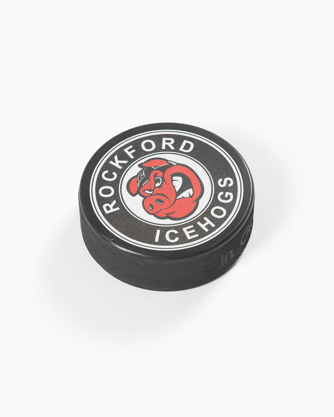 black hockey puck with Rockford IceHogs logo on front - angled lay flat