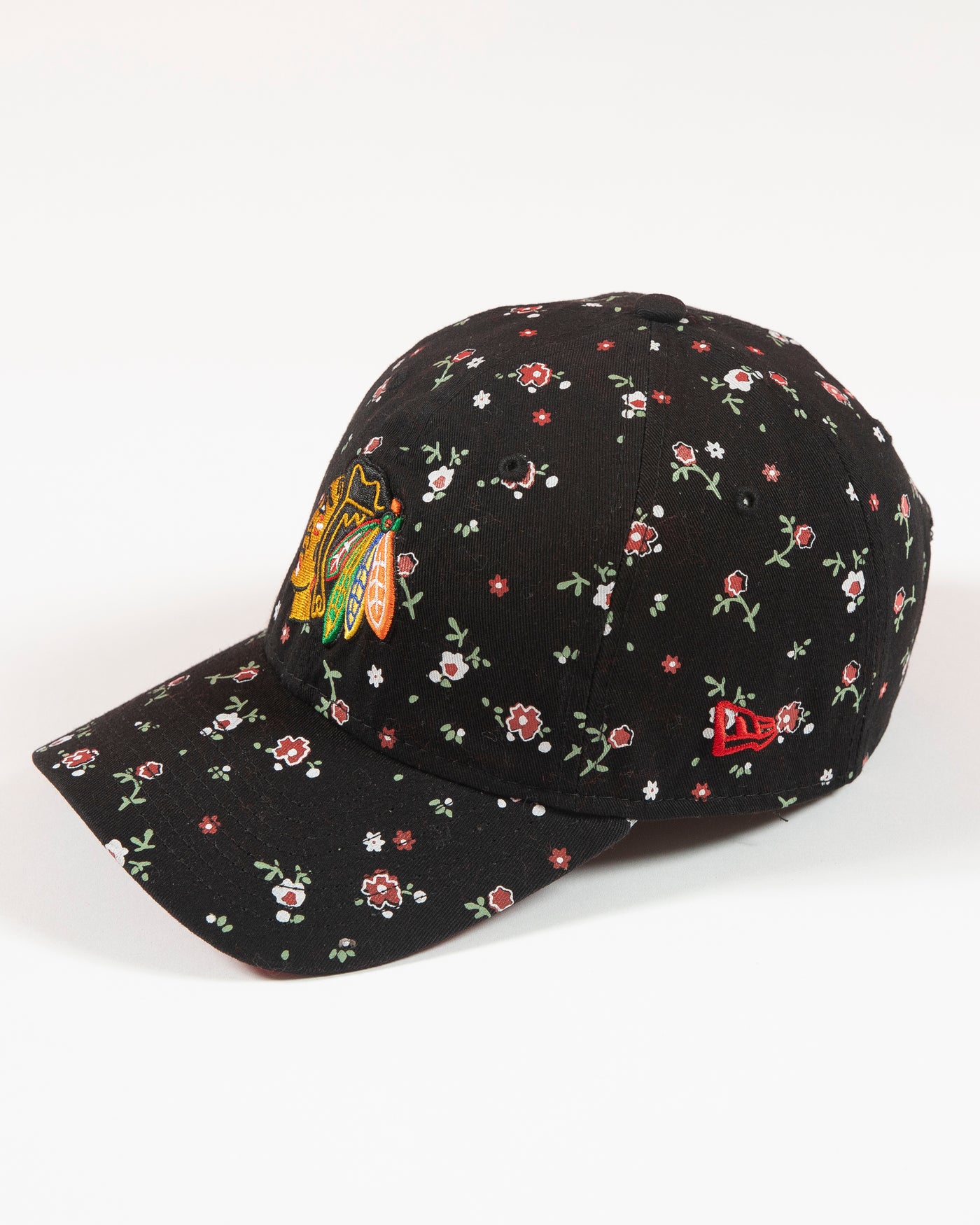 Black floral print New Era women's cap with Chicago Blackhawks primary logo embroidered on front - left angle lay flat