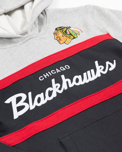 grey, black and red Mitchell & Ness youth hoodie with Chicago Blackhawks wordmark across chest and primary logo on left chest - detail lay flat