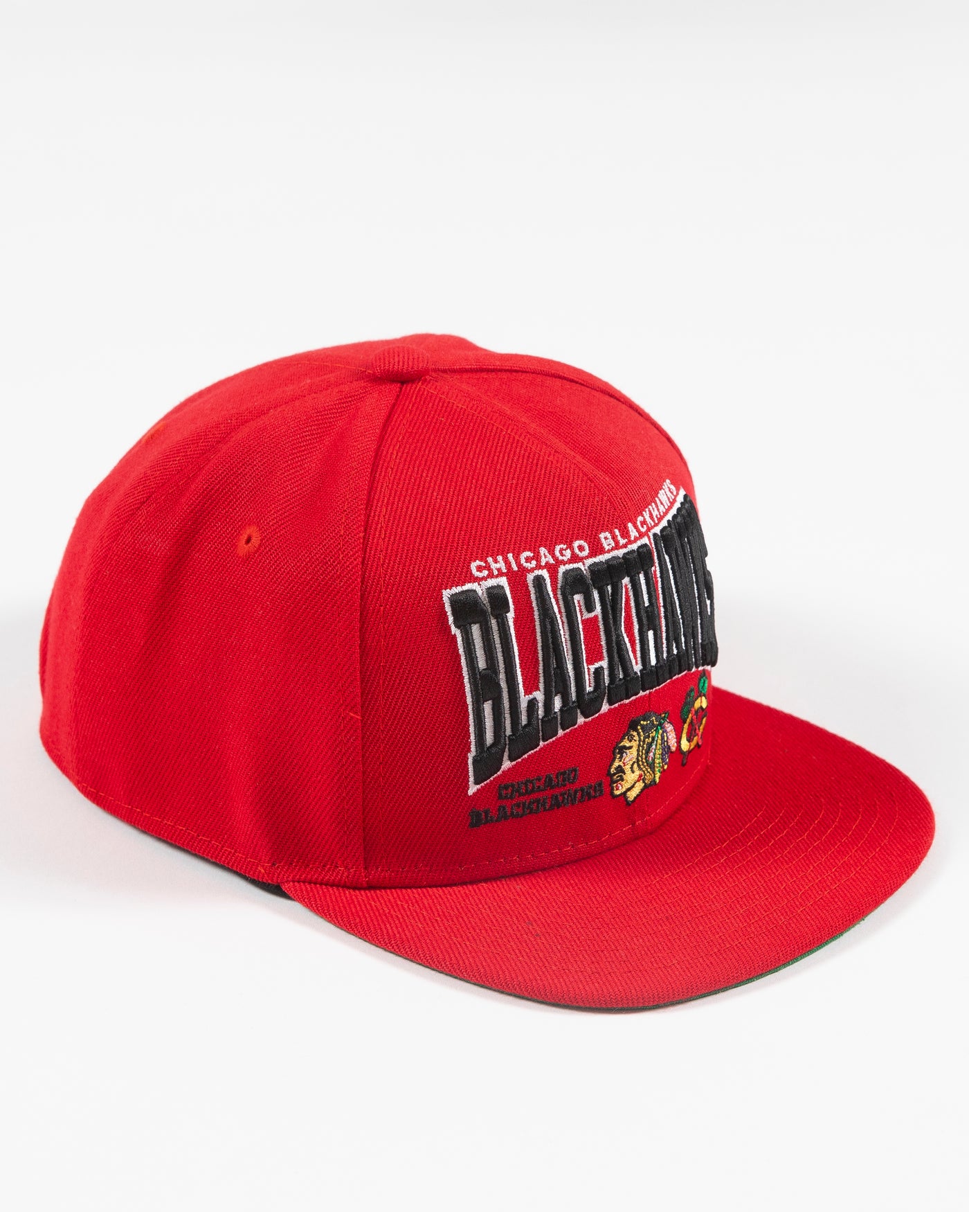 red Mitchell & Ness youth snapback with Chicago Blackhawks wordmark graphic and primary and secondary logos embroidered on front - right angle lay flat