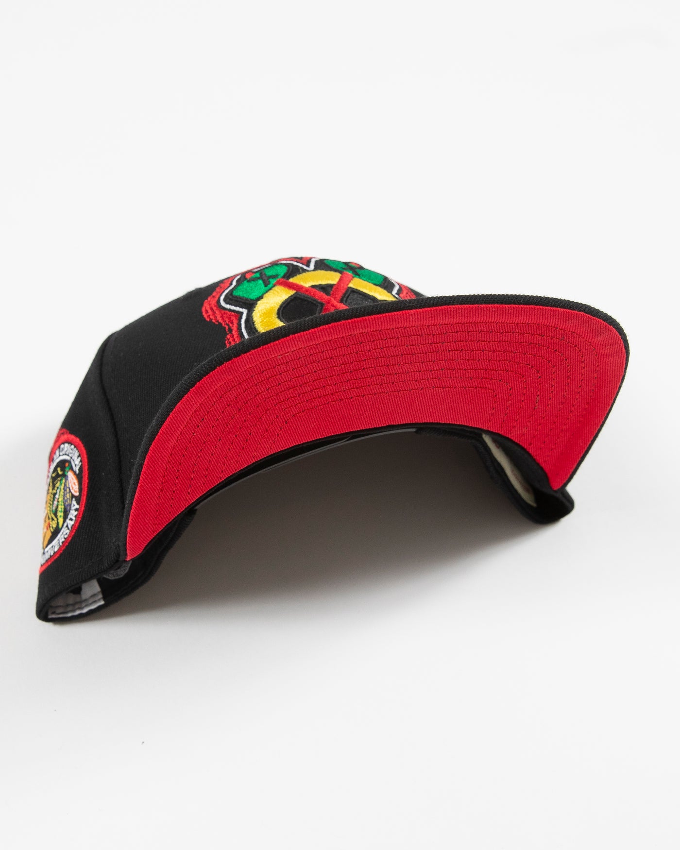 black youth Mitchell & Ness snapback cap with Chicago Blackhawks secondary tomahawk logo embroidered on front and 75th anniversary patch embroidered on right side - under brim detail
