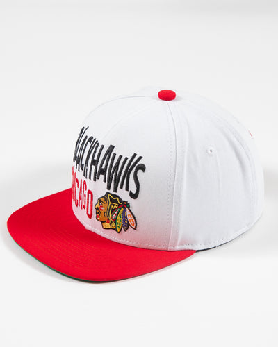 white and red Mitchell & Ness youth snapback with Chicago Blackhawks wordmark and primary logo embroidered on front - left angle lay flat