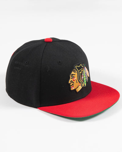 black and red Mitchell & Ness youth snapback with Chicago Blackhawks primary logo embroidered on front - right angle lay flat