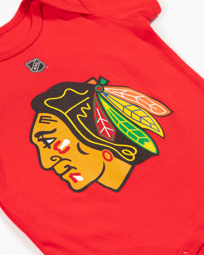 Red Outerstuff newborn onesie with Chicago Blackhawks primary logo across front chest - detail lay flat