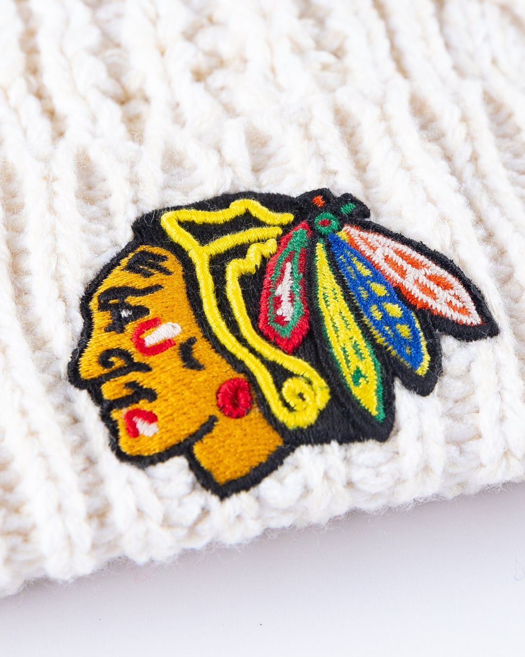 white '47 brand knit beanie with pom and Chicago Blackhawks primary logo embroidered on cuff - detail lay flat