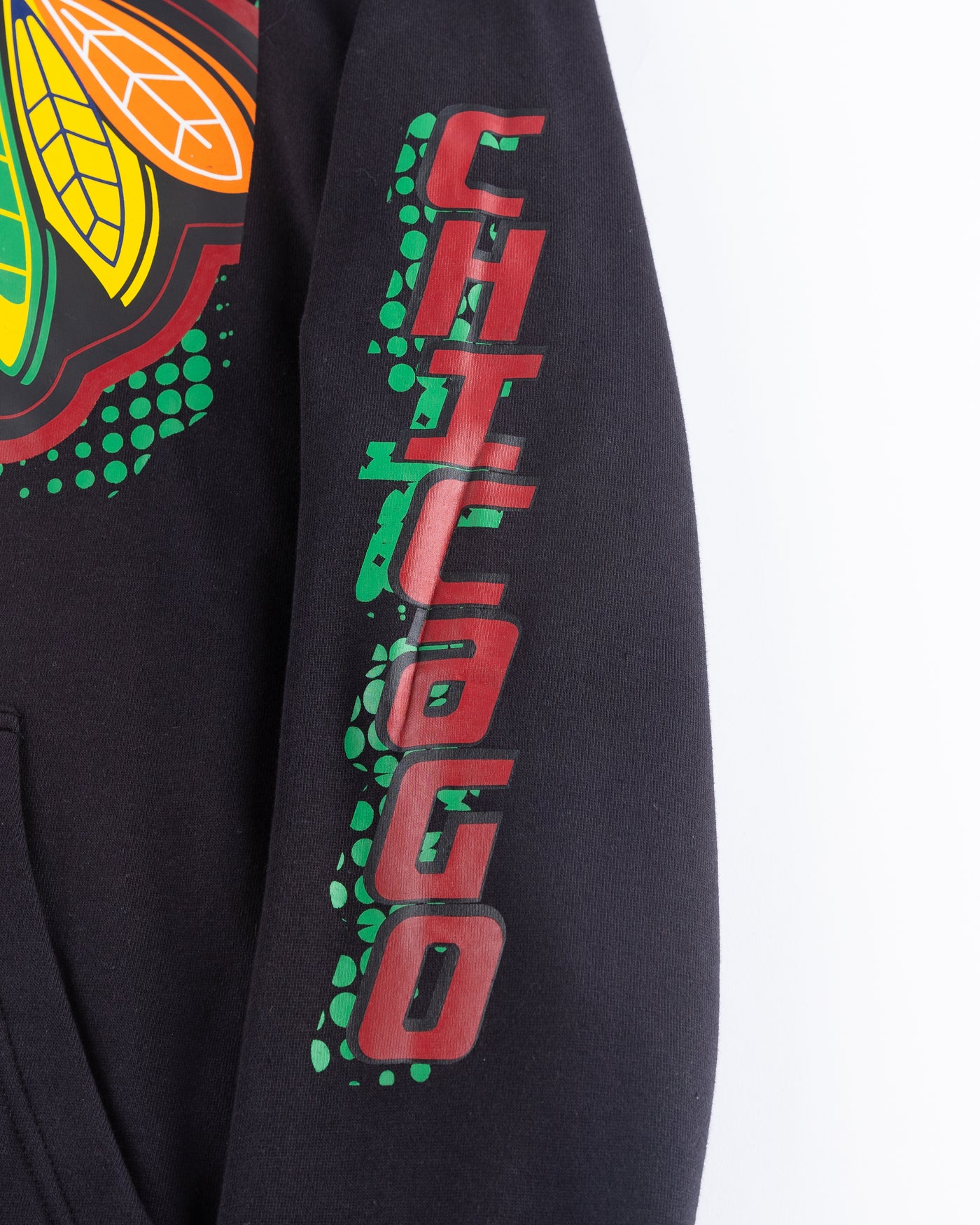 black Mitchell & Ness hoodie with Chicago Blackhawks primary logo across front and Chicago wordmark on left arm - detail arm lay flat