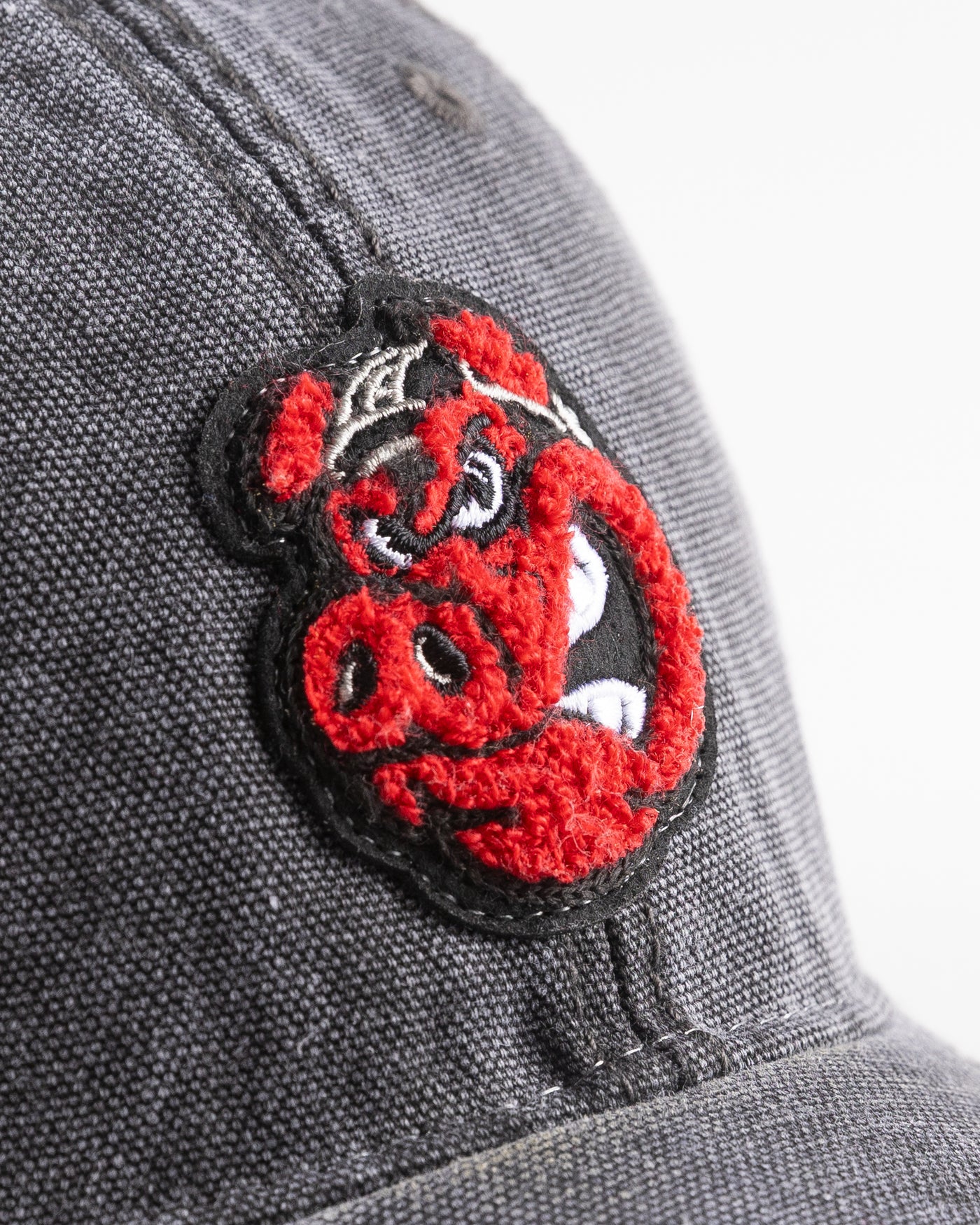 black/grey trucker cap with Rockford IceHogs Hammy embroidered design - detail lay flat 