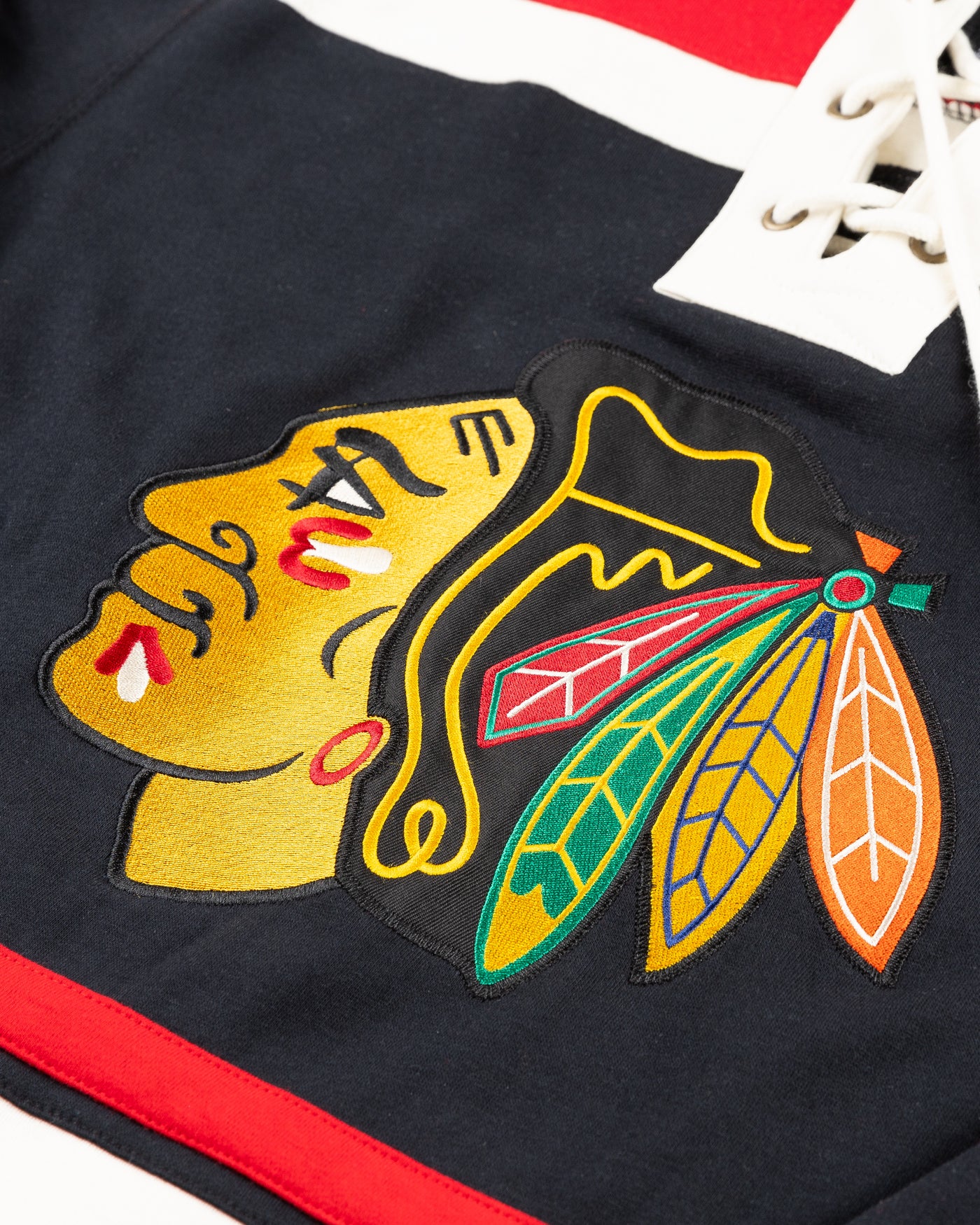 black and red '47 brand skate lace hoodie with Chicago Blackhawks primary logo embroidered on front and secondary logos embroidered on shoulders - detail lay flat