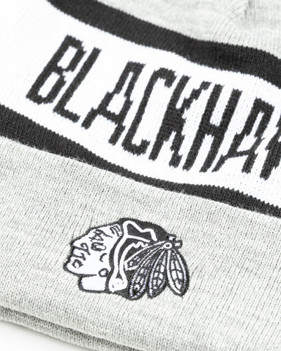 grey black and white knit beanie with Chicago Blackhawks primary logo embroidered on front and wordmark across - detail lay flat