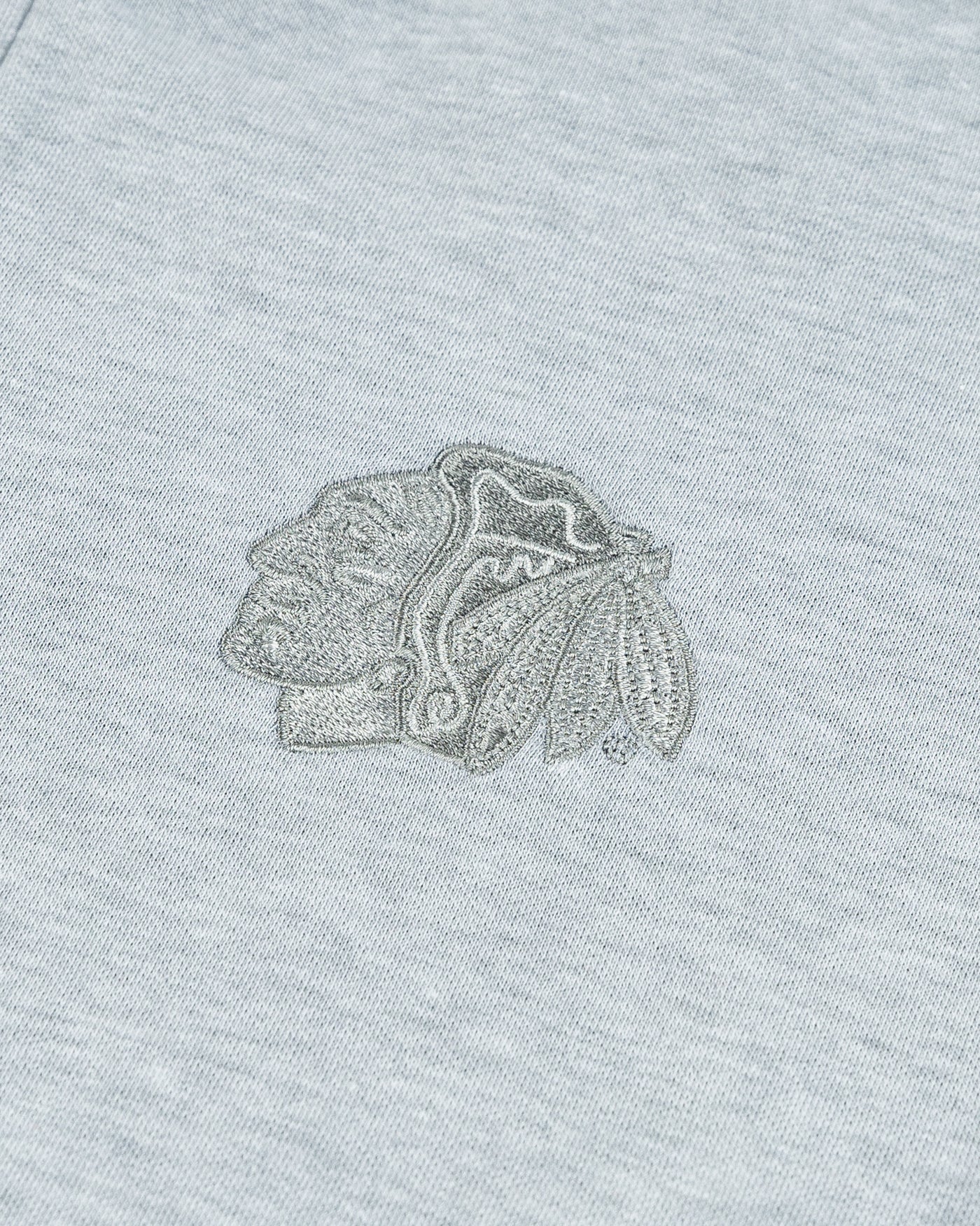 heather grey TravisMathew quarter zip with Chicago Blackhawks primary logo on left chest - detail  lay flat