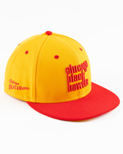 yellow and red New Era fitted cap with Chicago Blackhawks wordmark on front - right angle  lay flat