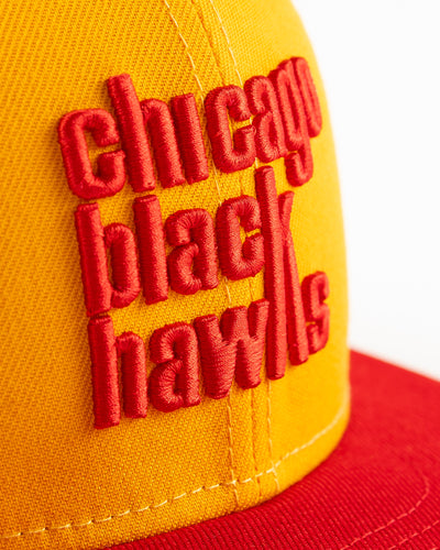 yellow and red New Era fitted cap with Chicago Blackhawks wordmark on front - detail lay flat