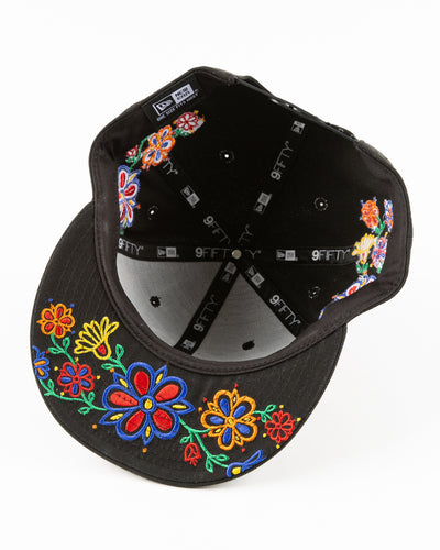 black New Era snapback with Chicago Blackhawks primary logo surrounded by floral pattern - under brim lay flat