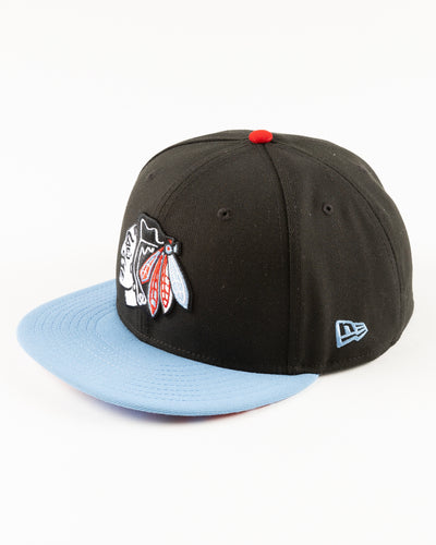 black and blue New Era fitted cap with tonal Chicago Blackhawks primary logo on front - left angle lay flat