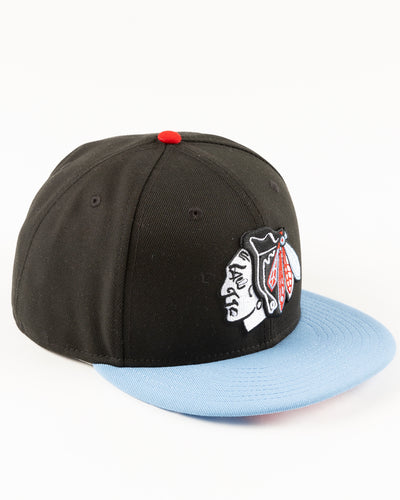 black and blue New Era fitted cap with tonal Chicago Blackhawks primary logo on front - right angle lay flat
