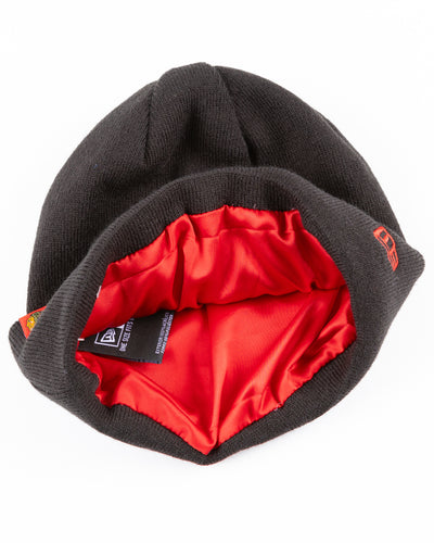 black New Era beanie lined with red satin with Chicago Blackhawks primary logo on tag on front cuff - detail inside lay flat