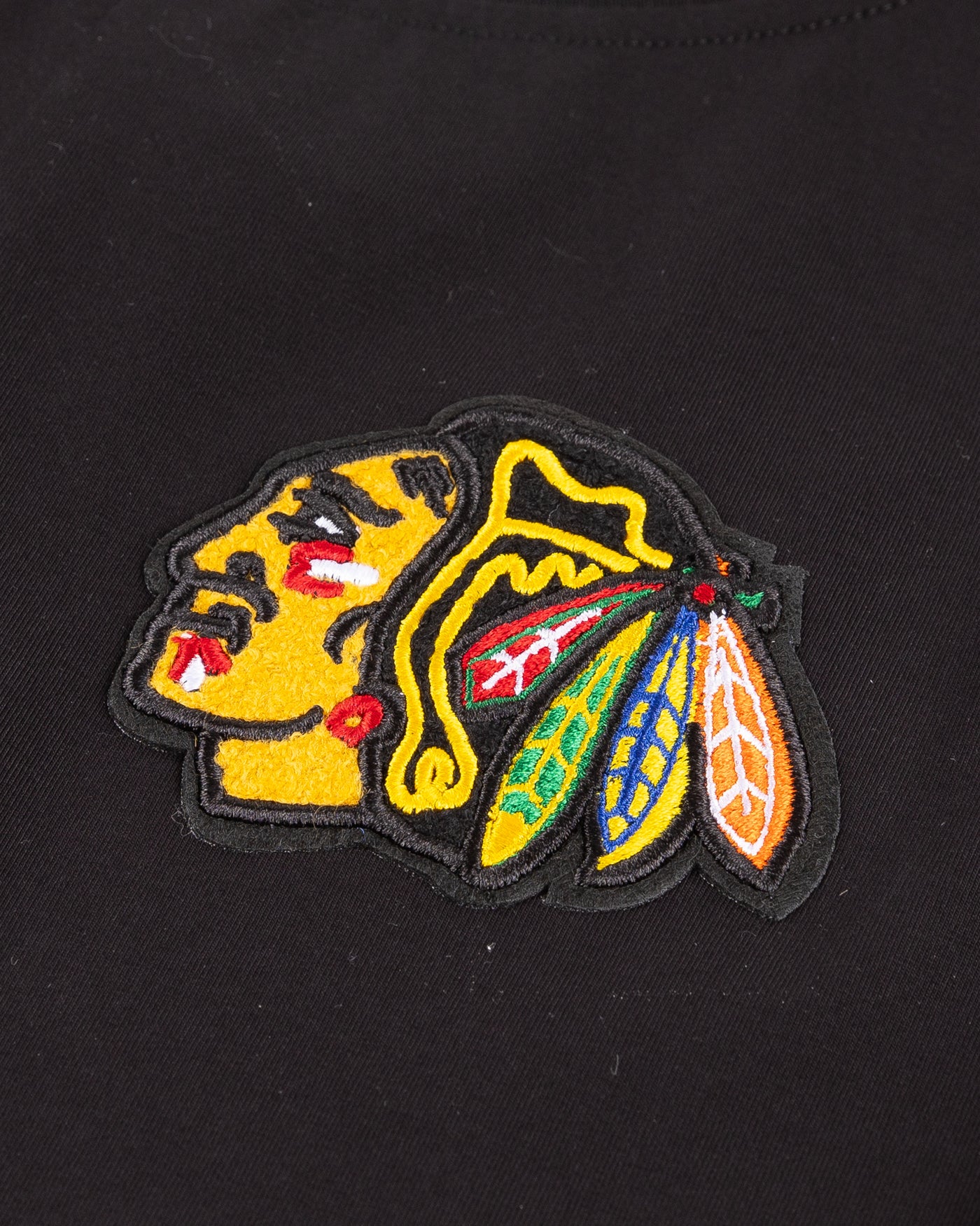 black cropped tee with embroidered Chicago Blackhawks patches on chest, shoulder and back - primary logo detail lay flat