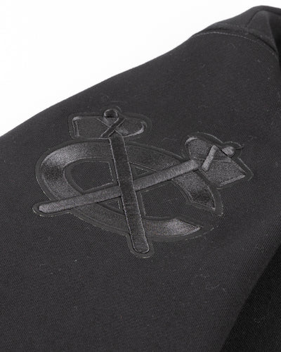 all black crewneck with tonal Chicago Blackhawks patches embroidered on front and shoulders - detail shoulder lay flat
