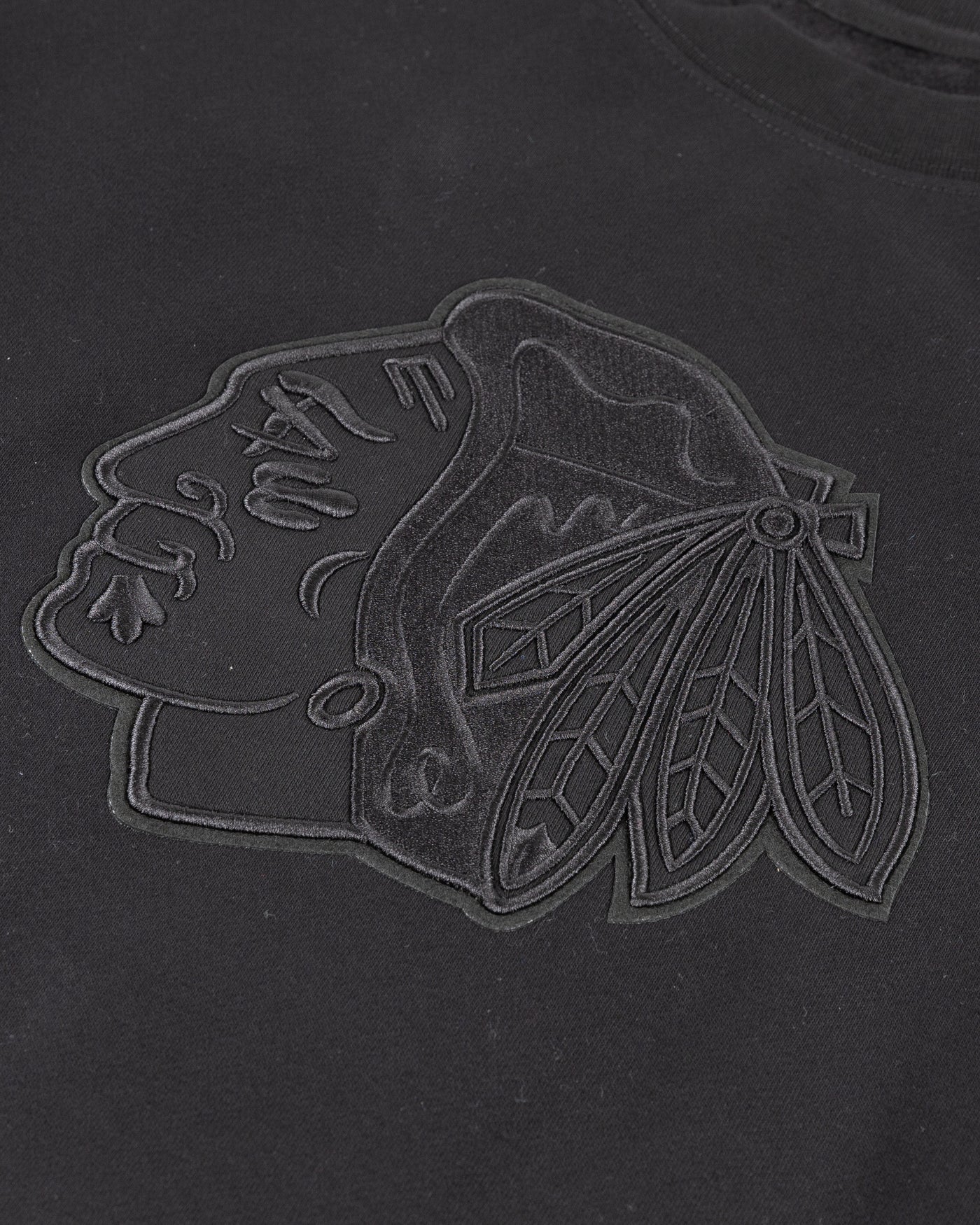 all black crewneck with tonal Chicago Blackhawks patches embroidered on front and shoulders - detail front lay flat