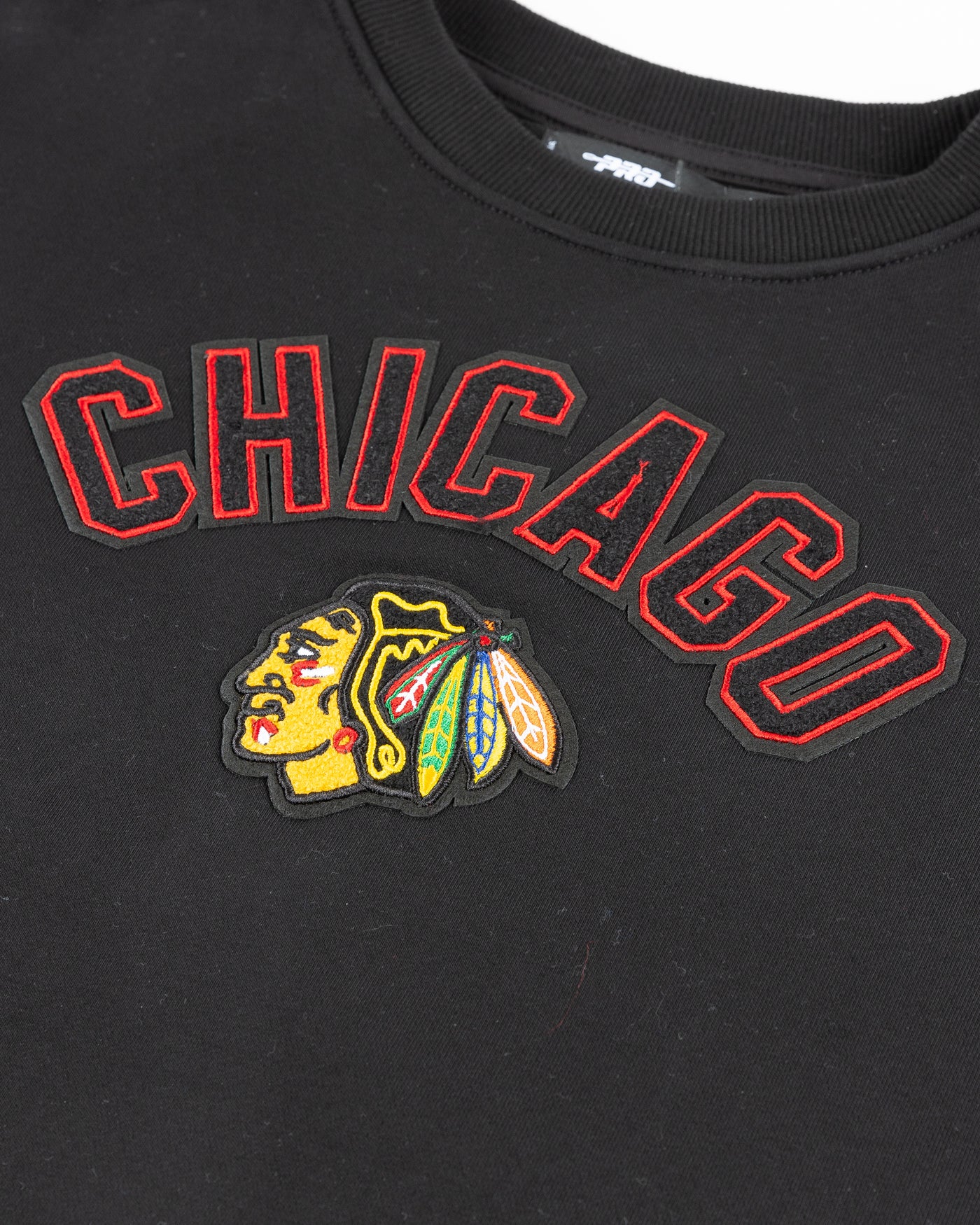 black cropped Pro Standard crewneck with embroidered Chicago Blackhawks patches on chest and shoulder - detail front lay flat
