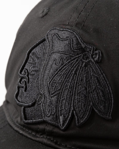 all black adjustable cap with tonal Chicago Blackhawks primary logo embroidered on front - detail front lay flat 