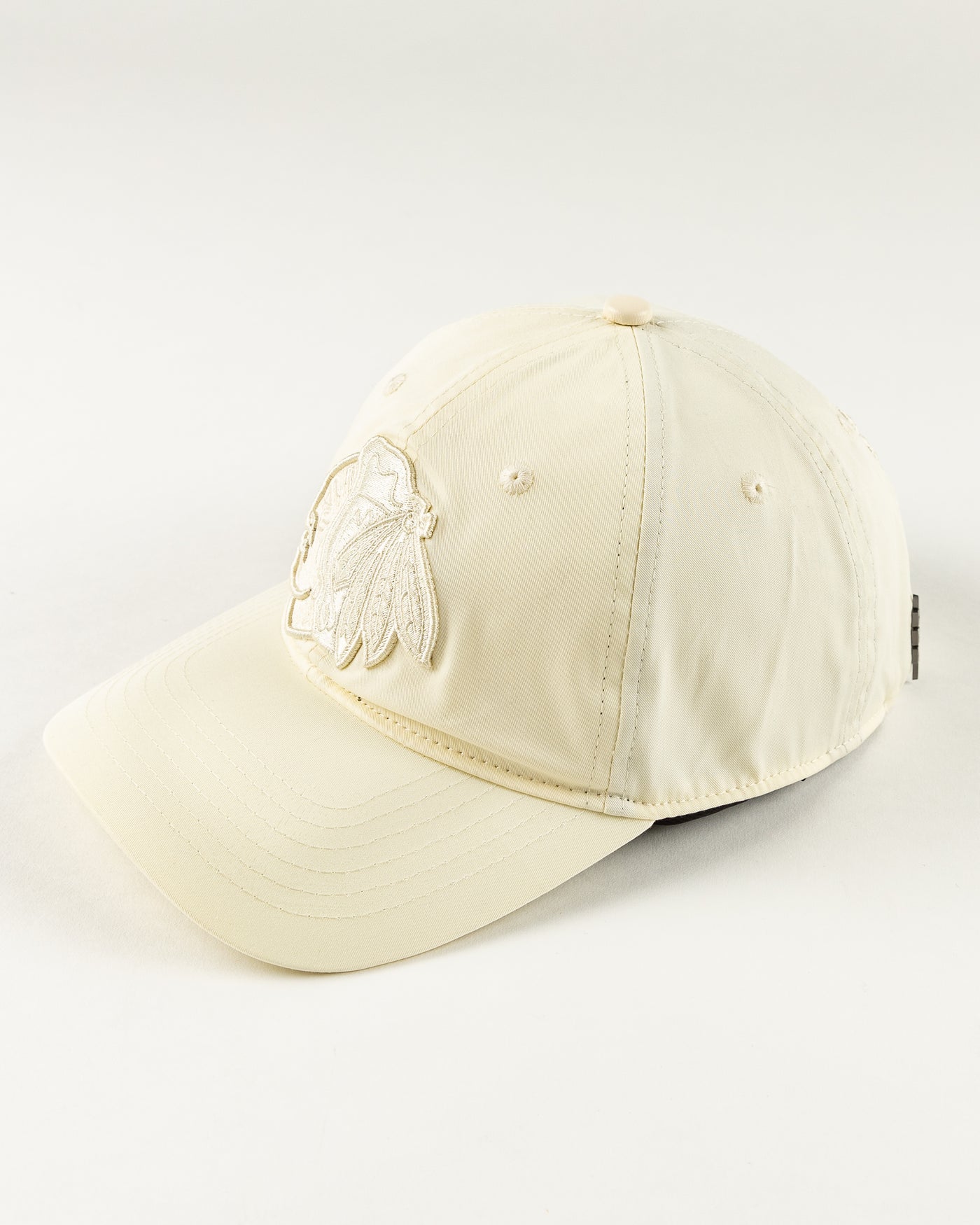 all eggshell adjustable cap with tonal Chicago Blackhawks primary logo embroidered on front - left angle lay flat 