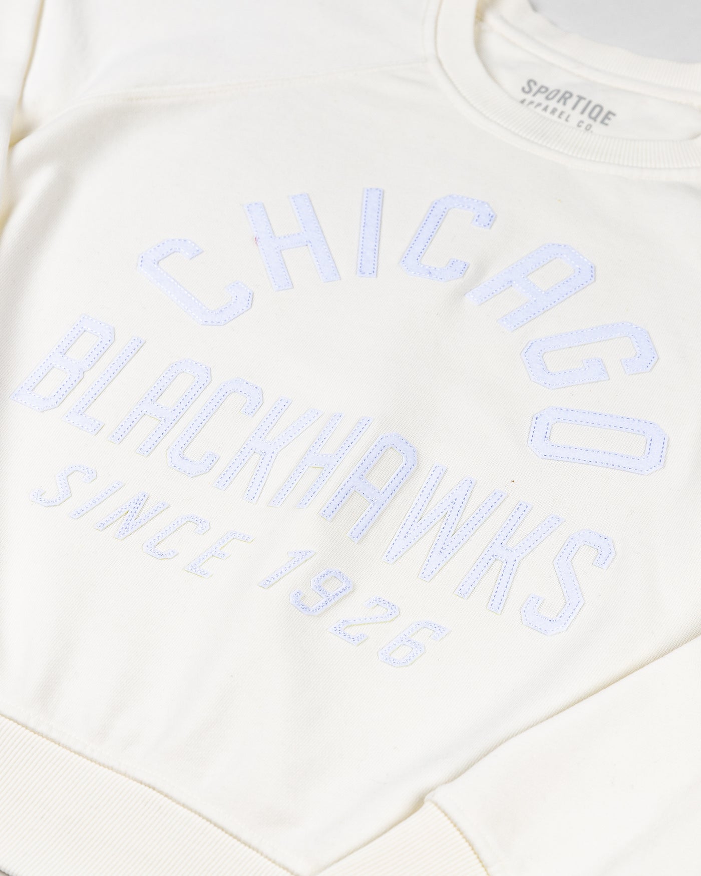 white Sportiqe ladies crewneck with tonal Chicago Blackhawks wordmark graphic embroidered across front - detail lay flat