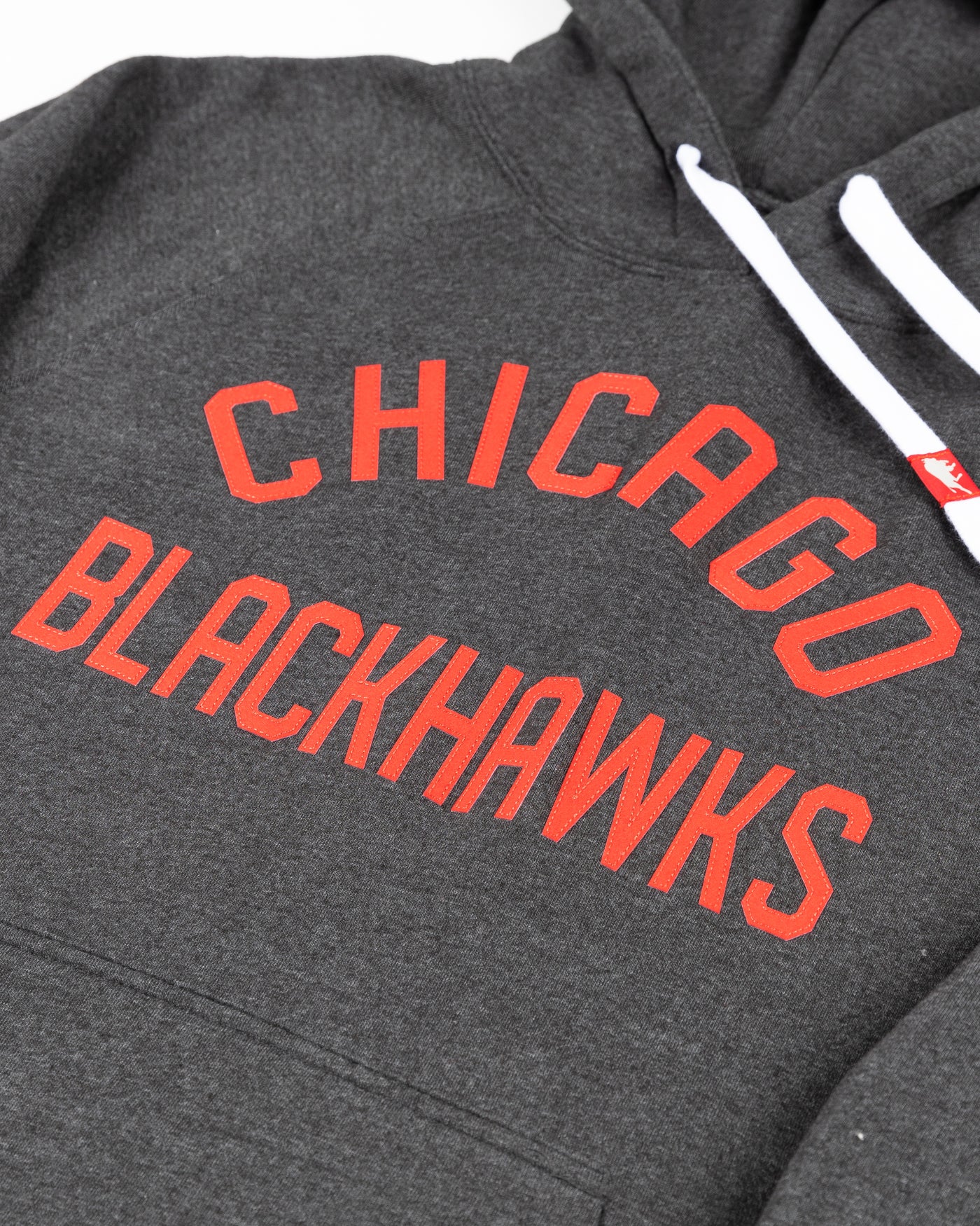 black Sportiqe hoodie with Chicago Blackhawks wordmark embroidered on front - detail lay flat
