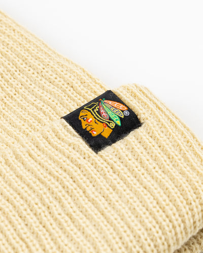 cream colored Sportiqe knit beanie with Chicago Blackhawks primary logo patch stitched on front cuff - detail lay flat