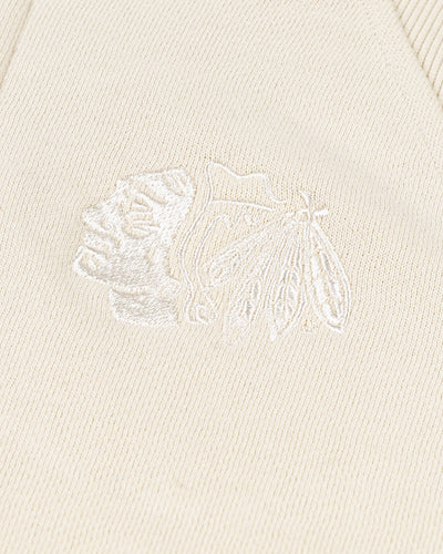 cream colored lululemon cropped ladies half zip with tonal Chicago Blackhawks primary logo embroidered on left chest - detail lay flat
