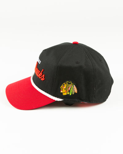 black and red rope snapback with Chicago Blackhawks wordmark across front and primary logo on left side - left side lay flat