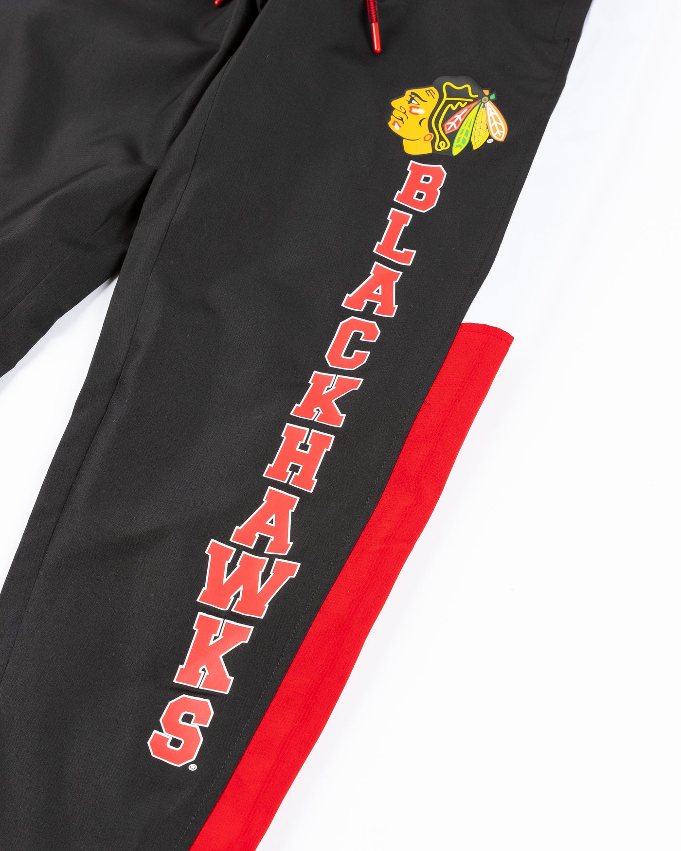 black red and white color blocked track pants with Chicago Blackhawks primary logo and wordmark on left leg - detail lay flat