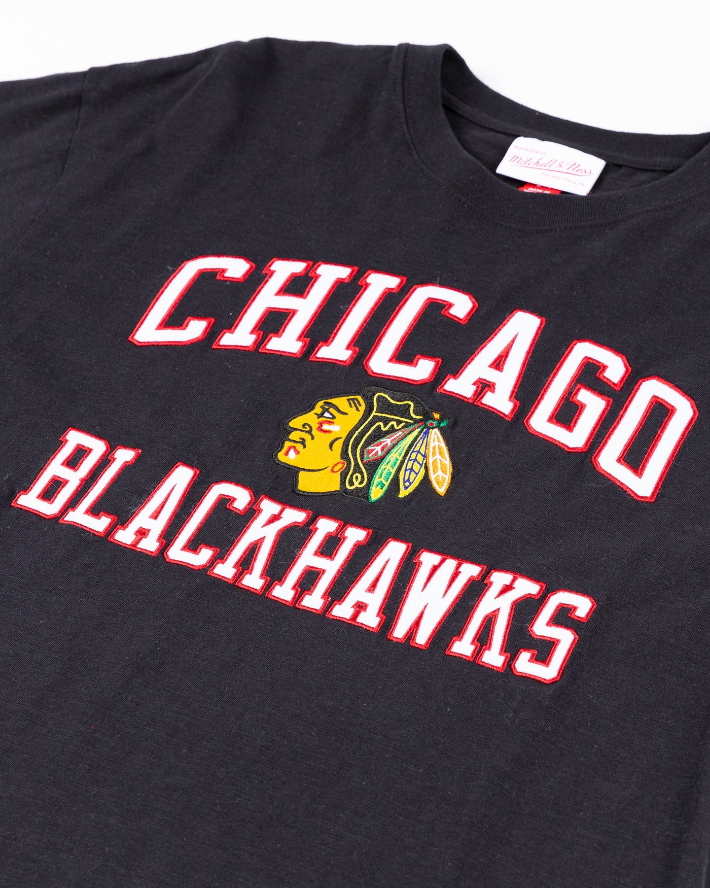 black Mitchell & Ness shirt with embroidered Chicago Blackhawks wordmark and primary logo on front - detail lay flat