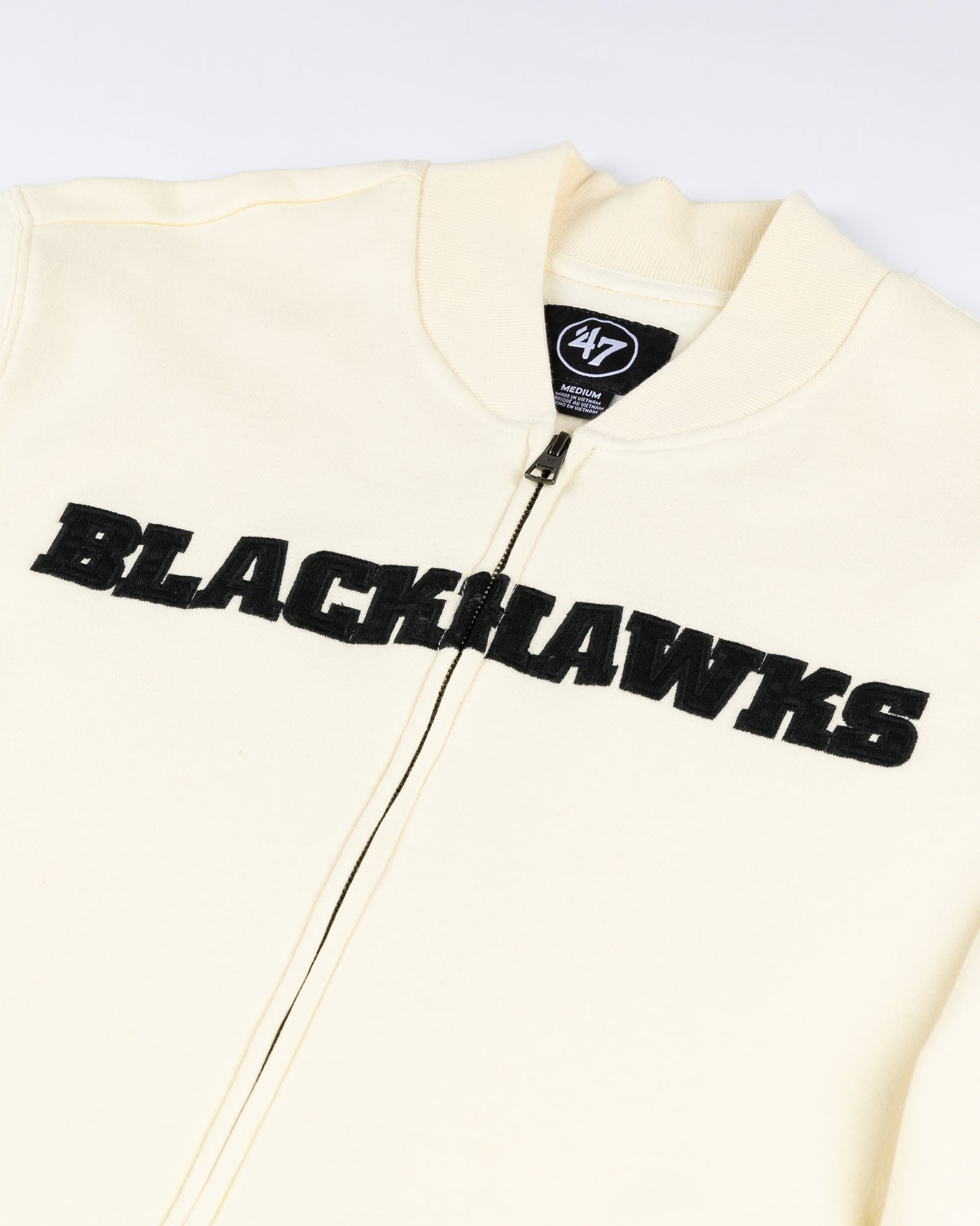 cream '47 brand full zip varsity jacket with Chicago Blackhawks wordmark across chest and primary logo on left shoulder - detail lay flat