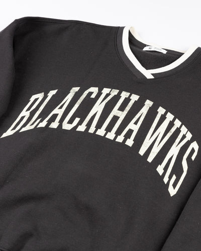 black '47 brand ladies v neck sweater with Chicago Blackhawks wordmark on front and primary logo on left shoulder - detail lay flat
