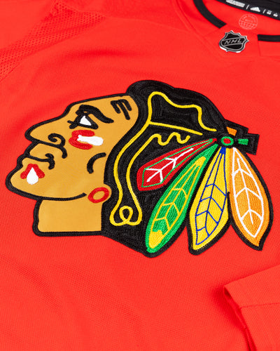 red adidas Chicago Blackhawks jersey with Kevin Korchinski name and number stitched - front detail lay flat