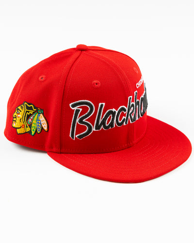 red youth New Era snapback cap with Chicago Blackhawks embroidered wordmark and primary logo on right side - right angle lay flat