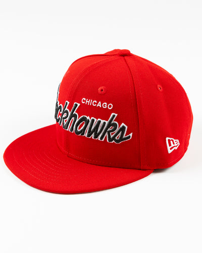 red youth New Era snapback cap with Chicago Blackhawks embroidered wordmark and primary logo on right side - left angle lay flat