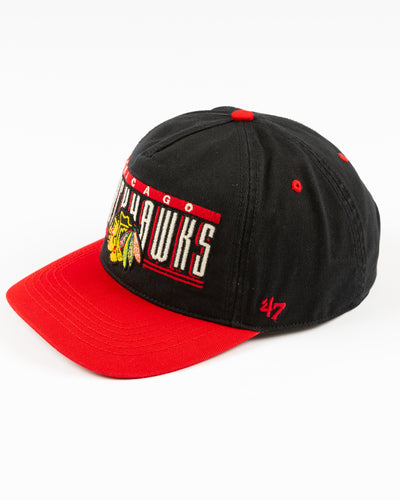 black and red '47 brand snapback hat with Chicago Blackhawks wordmark and primary logo embroidered on the front - left angle lay flat