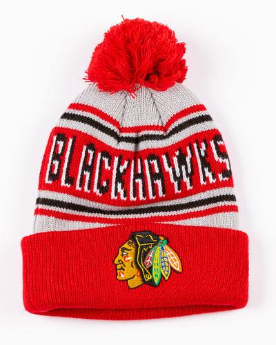 New Era knit hat with pom with Chicago Blackhawks wordmark across front and embroidered primary logo on cuff - front lay flat
