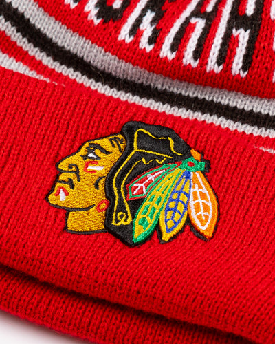 New Era knit hat with pom with Chicago Blackhawks wordmark across front and embroidered primary logo on cuff - detail lay flat