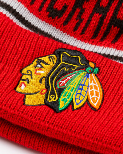 New Era knit youth beanie with pom with Chicago Blackhawks wordmark and primary logo embroidered on cuff - detail lay flat