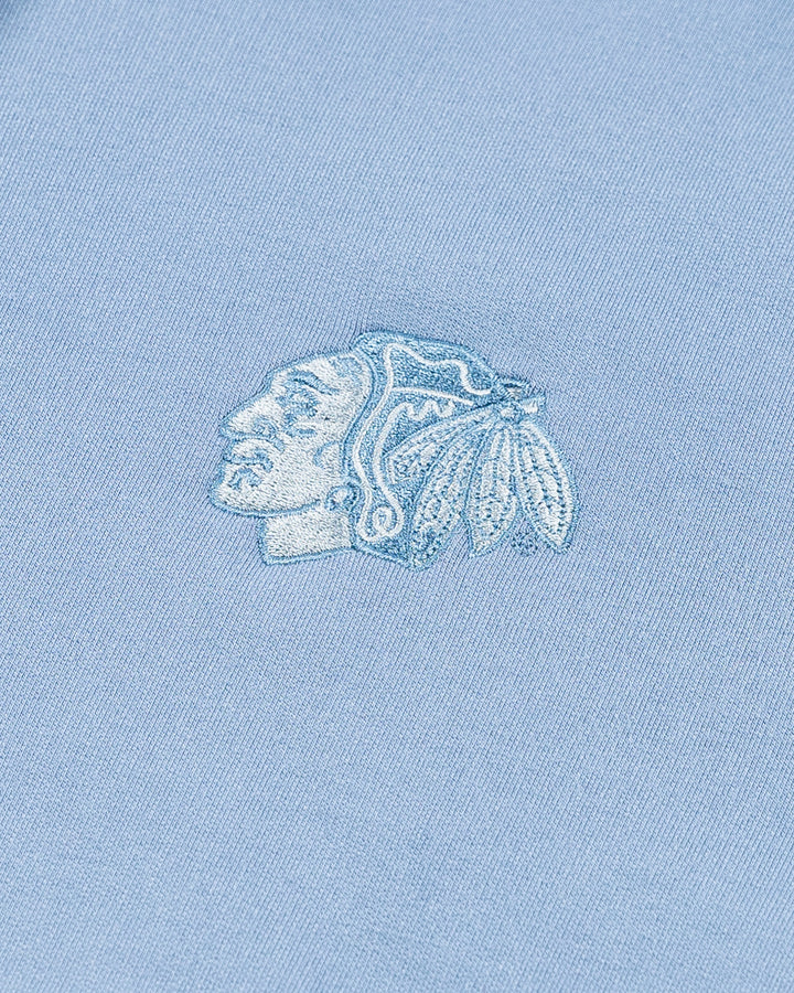 light blue TravisMathew hoodie with Chicago Blackhawks tonal primary logo embroidered on left chest - detail lay flat